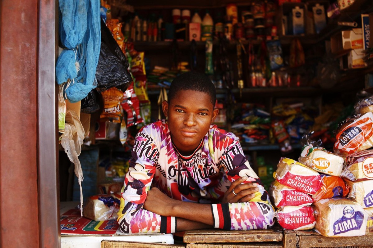 Small trader at a market shop counter, a typical microfinance borrower